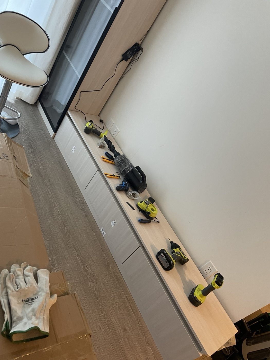 Furniture installation in progress with tools and cabinet units